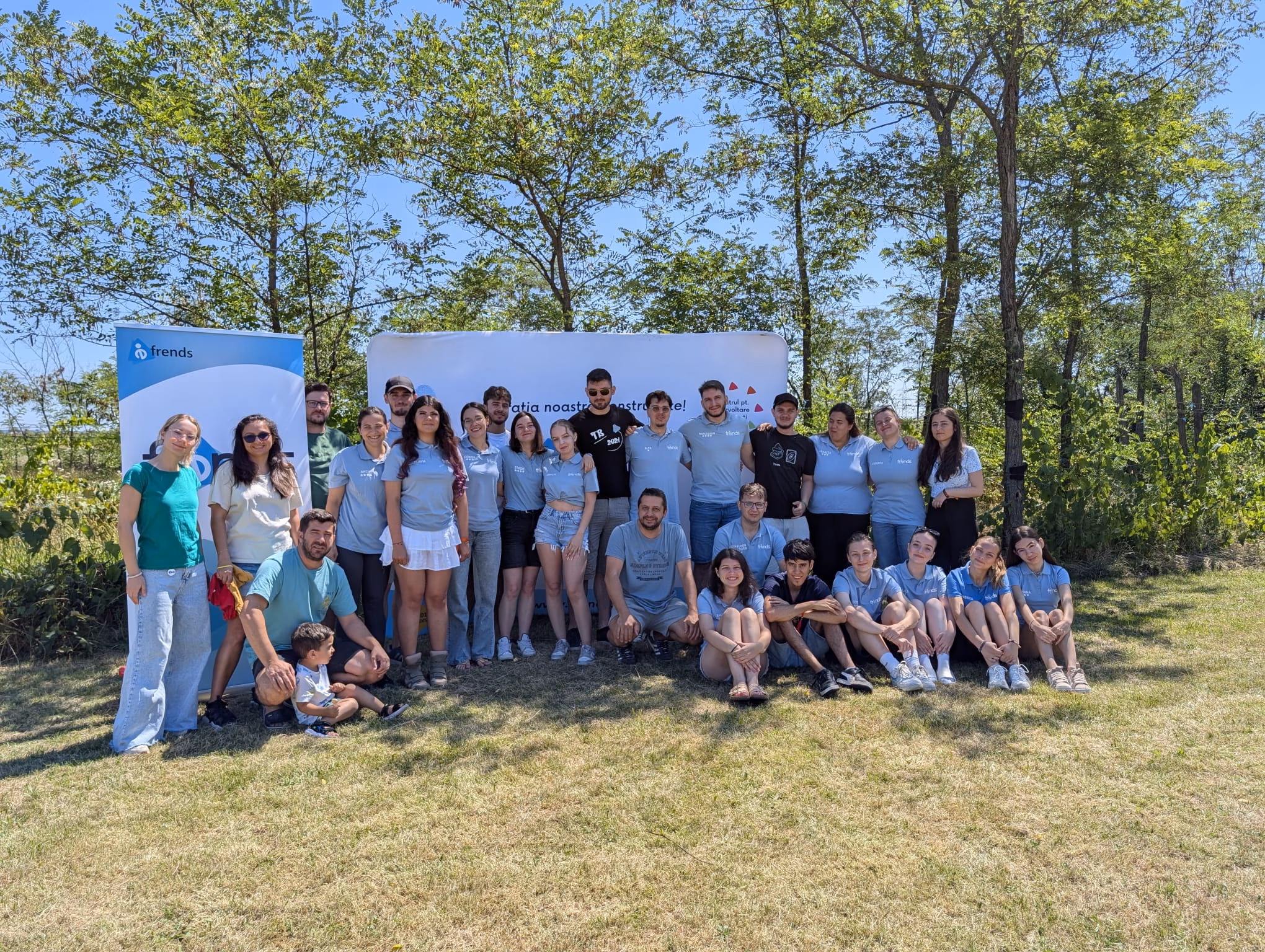 Voluntarii FRENDS în fața bannerului asociației, la Oarja